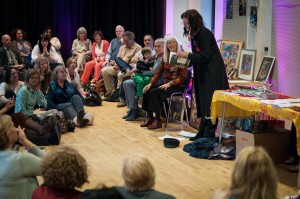 Mary Smail reading from the book. Next to her, Frankie Armstrong and Jenny Pearson, with her grandson Dylan on her knee.