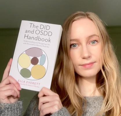 Ella Everett holds up their book The DID and OSDD Handbook